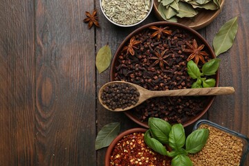 Different aromatic spices on wooden table, flat lay. Space for text