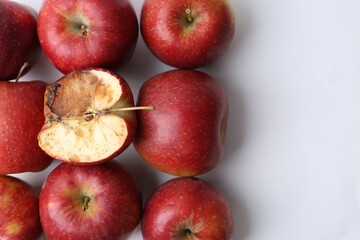 Spoiled apple and good ones on white background, flat lay
