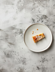 Slice of cake on a minimalist plate against a textured background  