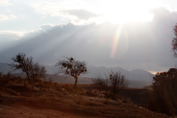 silhouette mountains, light beam through clouds