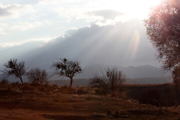 silhouette mountains, light beam through clouds