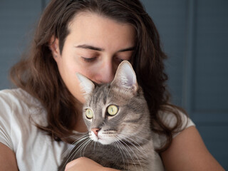 Femme tenant son chat les yeux fermés, sentant son odeur