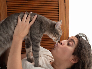 Femme blanche tenant un chat gris et l'embrassant