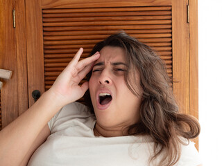 Jeune femme brune avec mal de tête, main sur le front, douleur et migraine