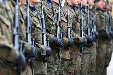 Uzbrojeni żołnierze w szeregu w mundurach Armia Polska.  © FotoDax