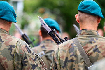 Uzbrojeni żołnierze w szeregu w mundurach Armia Polska.  © FotoDax