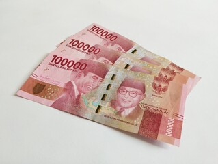 Several Indonesian rupiah banknotes displayed on a plain surface, highlighting financial wealth and...
