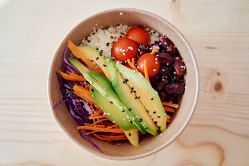 Colorful avocado quinoa bowl with fresh vegetables and cherry tomatoes