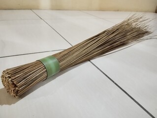Natural broom on tiled floor highlights traditional cleaning tools for a spotless home and...