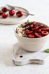 Buckwheat porridge with fresh sweet cherries, berry jam, and almonds. Vegan breakfast bowl