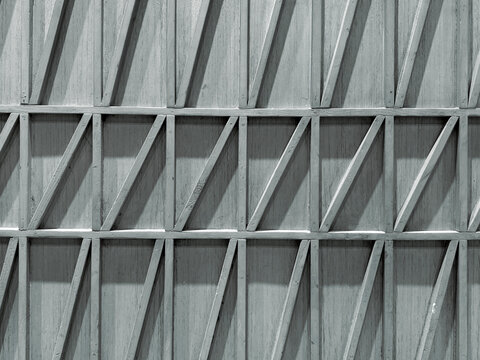 Close up of geometrical wood wall panel in slanted strips, rectangles, and triangular pattern. Modern interior design geometric screens or wall decoration. Seamless background texture.