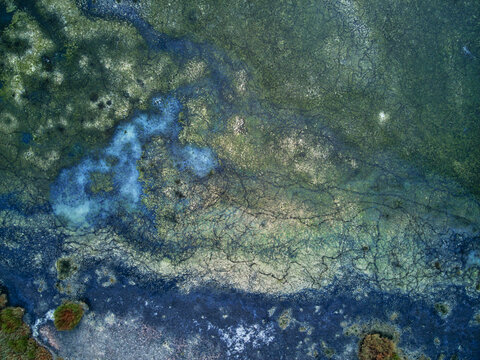 Aerial view of a tapestry of teal and emerald waters intertwines with earthen hues, creating a mesmerizing mosaic of nature's artistry, Kalochori, Thessaloniki, Greece.