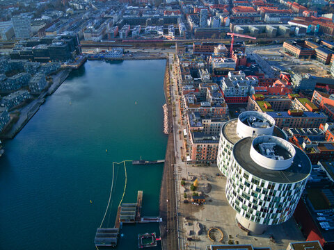 Aerial view of the vibrant contrast between the dark harbor waters and the modern architecture of the Gemini Residence, Copenhagen, Denmark.