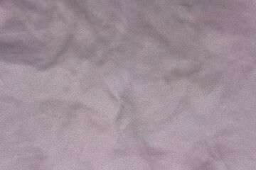 A light gray fabric surface revealing subtle textures and gentle wrinkles, evoking a sense of simplicity and naturalness.