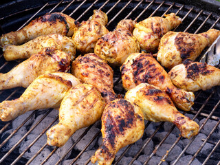 Chicken legs are cooking on the grill