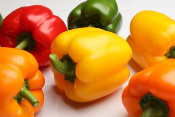 Fresh colorful bell peppers on light table, closeup
