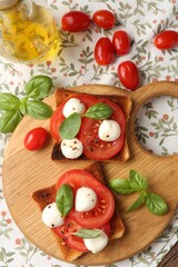 Tasty sandwiches with mozzarella cheese, tomatoes and basil on table, flat lay