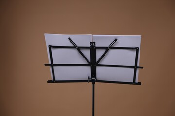 Stand with music sheets on dark beige background