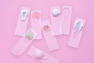 Slides with various cosmetic products: creams and serums on a pink background.