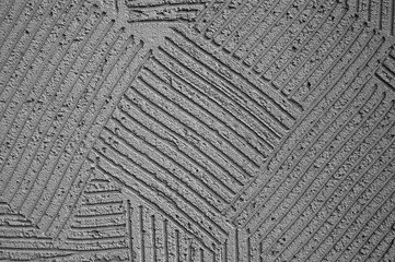 gray background, photo shows texture of decorative plaster on concrete wall close-up