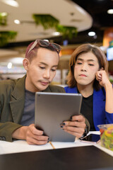 Gender diverse coworker business team eating salad and working digitally