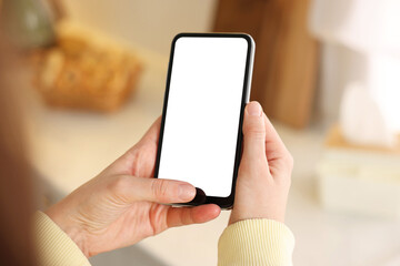 Woman using modern smartphone at home, closeup