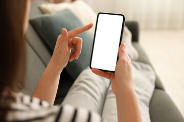 Woman using modern smartphone on sofa at home, closeup