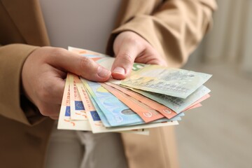 Woman counting her money indoors, closeup view