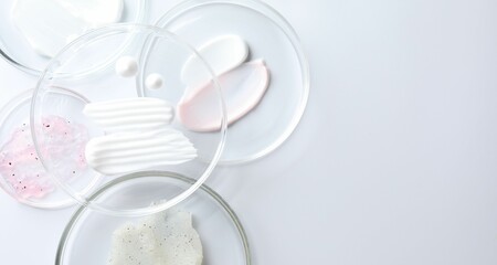 Different cosmetic products in Petri dishes on white background, flat lay. Space for text