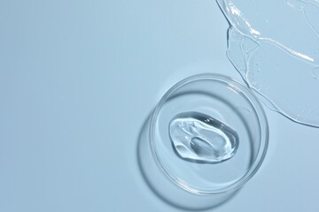 Cosmetic product in Petri dish on light blue background, top view. Space for text