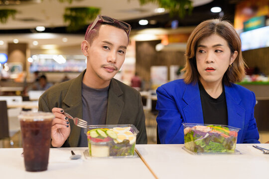 Gender diverse coworker business team eating salad and working digitally - Powered by Adobe