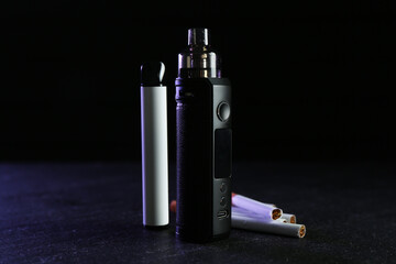 Electronic smoking devices and cigarettes on black table