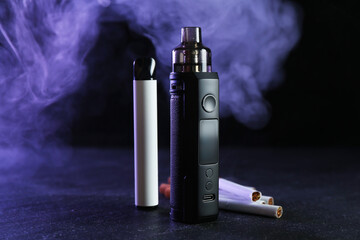 Electronic smoking devices and cigarettes on black table