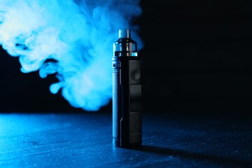 Electronic smoking device on black table in blue light