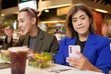 Gender diverse coworker business team eating salad and working digitally