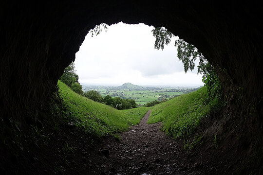 View from the entrance of a cave revealing a lush green landscape