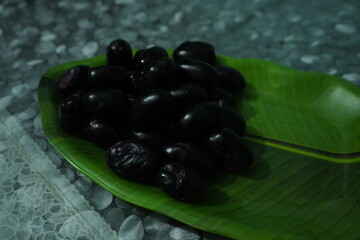 Smooth‑skinned, deep purple‑black round fruit with soft red or yellow flesh, sweet‑tart flavor, richly antioxidant and fiber‑packed