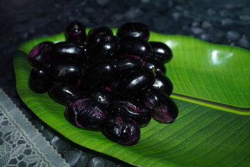 Smooth‑skinned, deep purple‑black round fruit with soft red or yellow flesh, sweet‑tart...