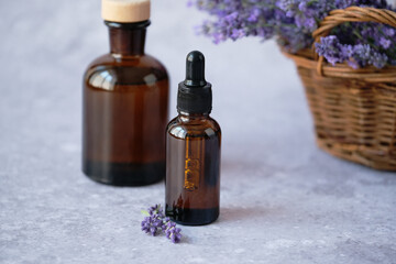 Herbal cosmetics amber glass bottles filled with lavender essential oil displayed alongside fresh lavender sprigs. Alternative medicine, healthy and well-being concept