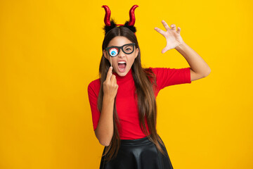 Little girl with pumpkin. Halloween witch girl. Teen witch. Kid girl witch celebrates Halloween....