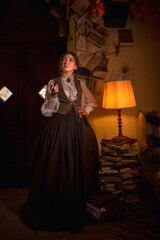beautiful woman scientist in retro style smokes a pipe in the library reading books