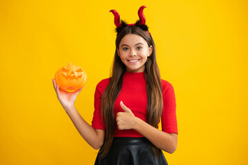 Child girl having fun on Halloween party. Funny little girl with pumpkin. Halloween witch girl....