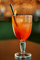 Refreshing citrus cocktail with straw and cherry garnish in elegant glass