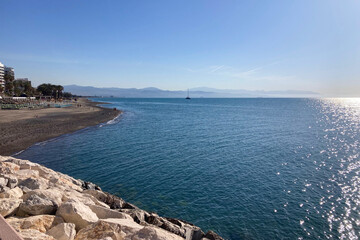 Enjoying a peaceful walk along the seaside promenade of Torremolinos, Spain, with scenic coastal...