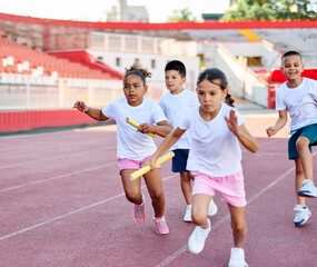 Children running on track at the stadium, practice during sports class in school training Little...