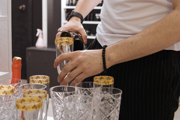 A man pours alcohol into glasses. Champagne on holiday
