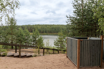 Latvian lake landscape with wooden stairs and pine forest