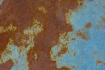 The surface of old metal shows a distinct texture of rust and remnants of blue paint. This...