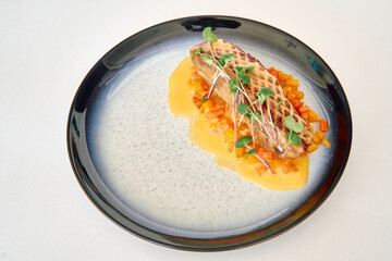 Seared duck breast with root vegetable medley on elegant blue ceramic plate