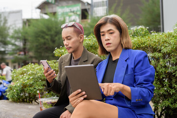 Gender diverse business coworker professionals using technology on city street